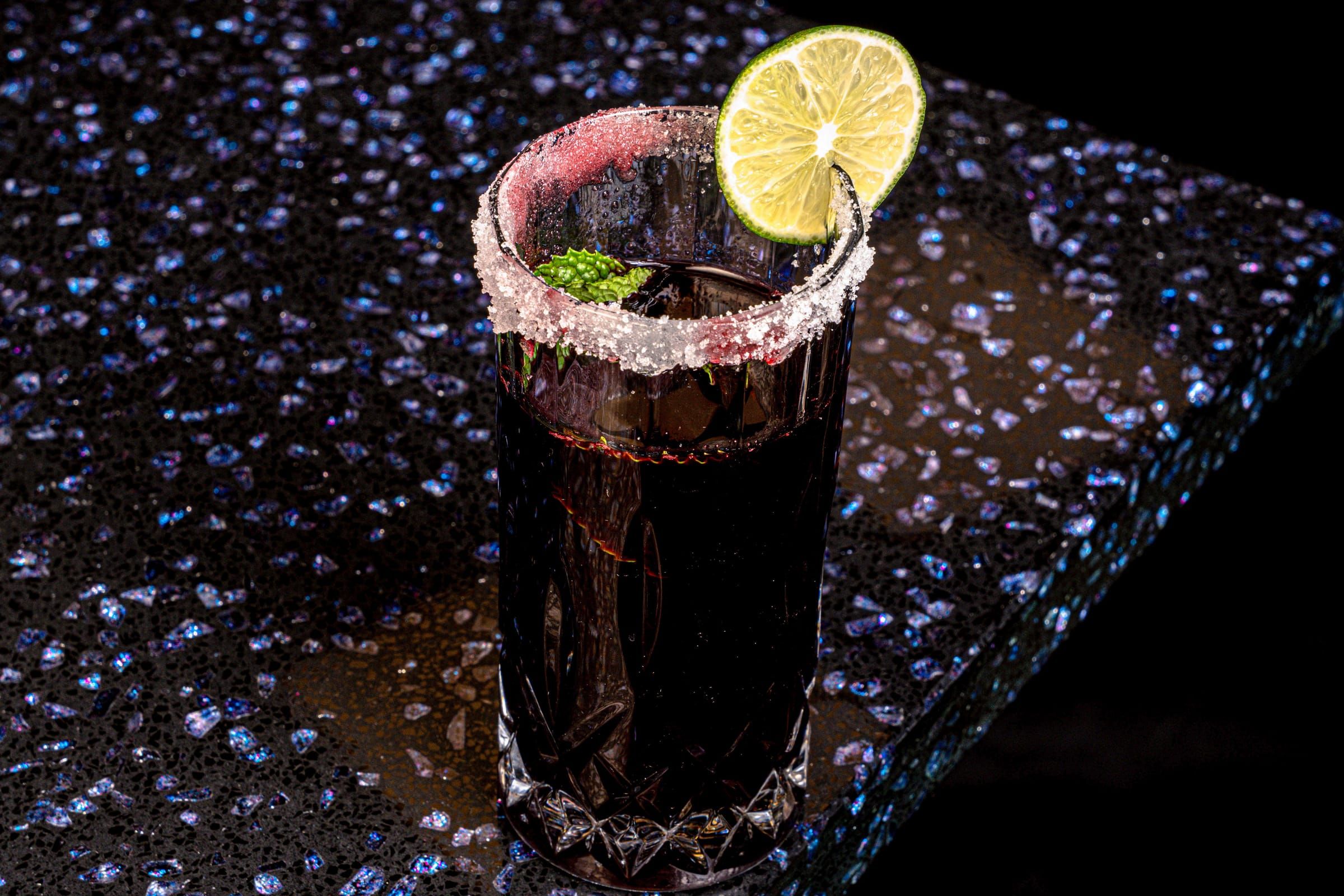 A tall glass of deep purple chicha morada